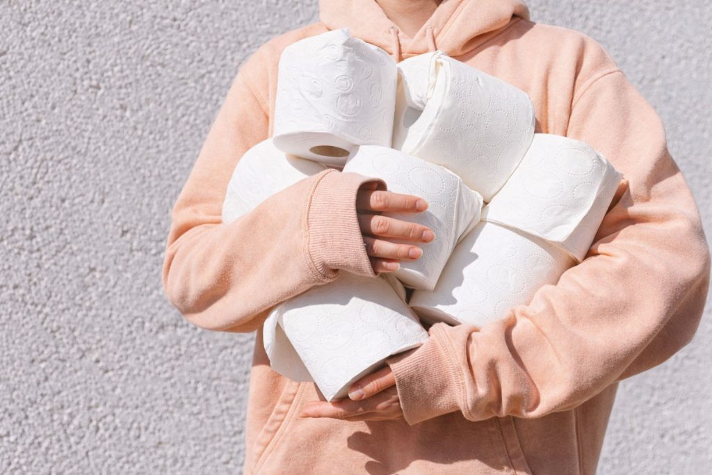 Person holding multiple tissue rolls highlighting the importance of choosing safe and gentle products for vaginal hygiene
