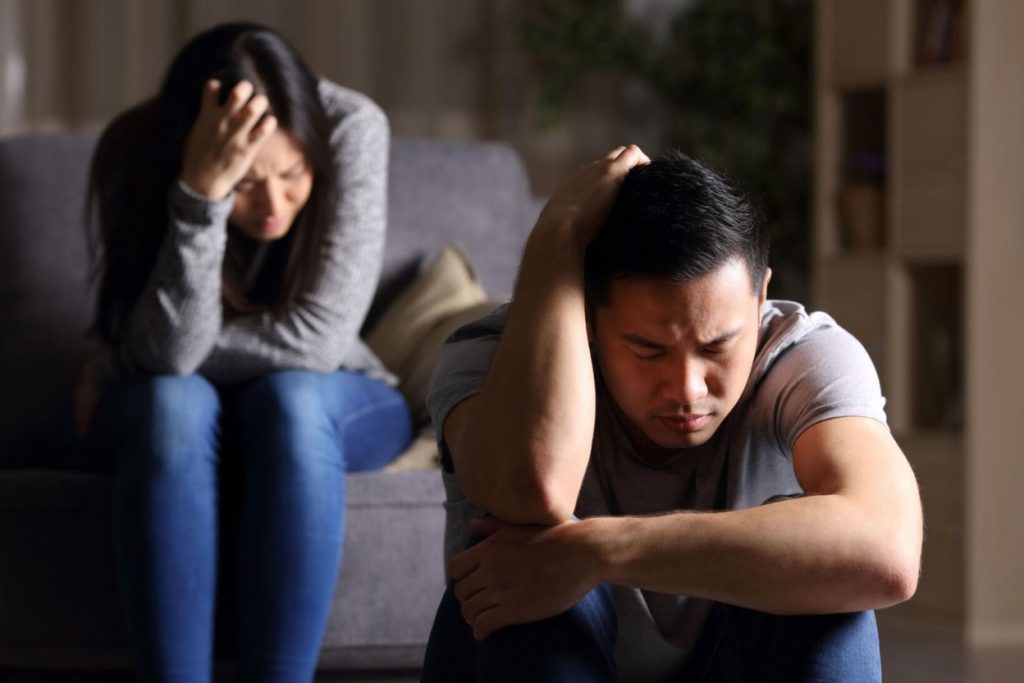 A distressed couple sitting apart, showing emotional tension and disconnection in a relationship that reflects why modern relationships fail.