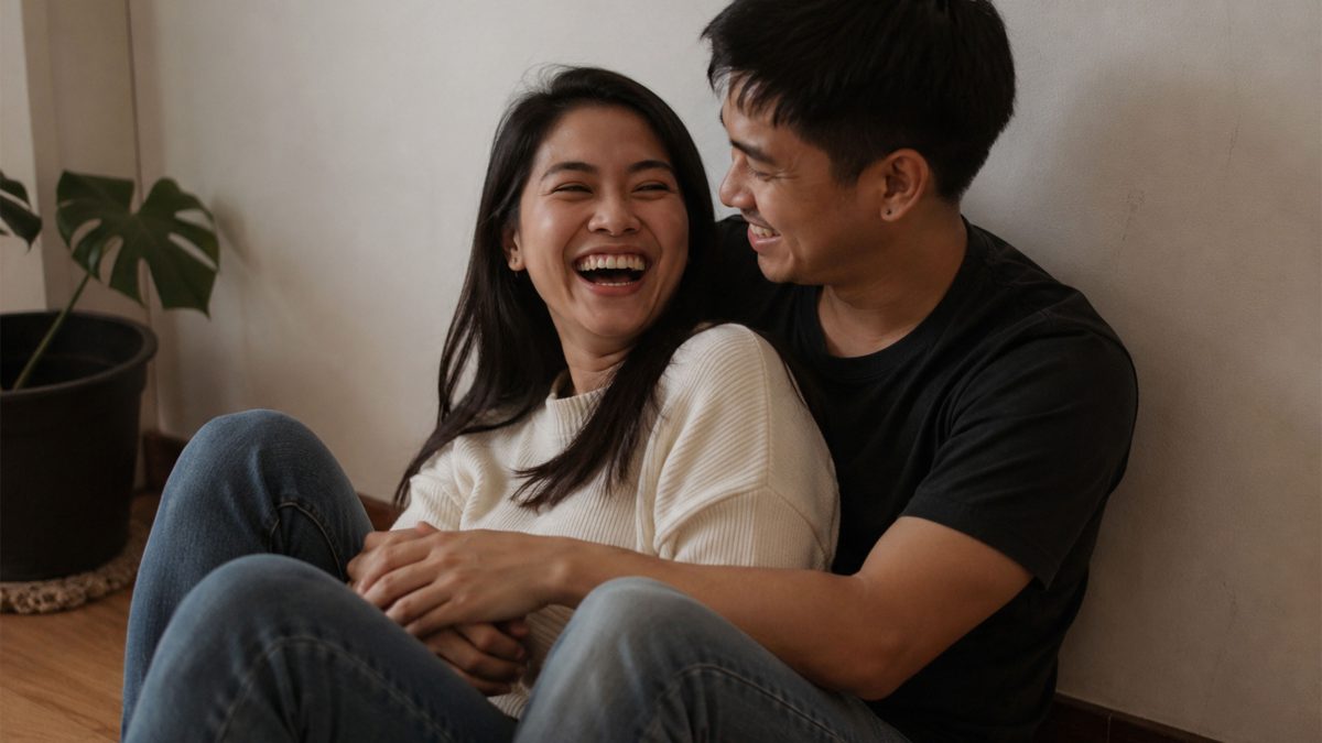 Filipino couple laughing together inside their home