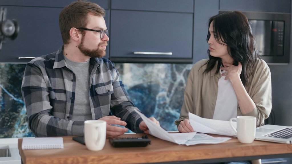 Filipino couple reviewing bills and expenses together at home while living together before marriage.