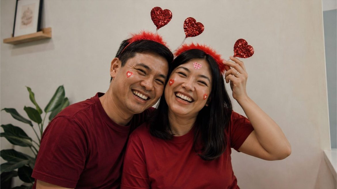 Filipino couple wearing heart headbands while laughing together indoors