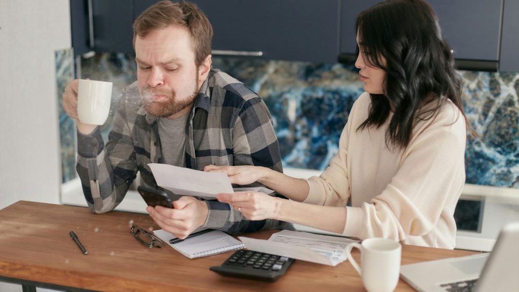 Young Filipino couple discussing finances and responsibilities inside their shared home.