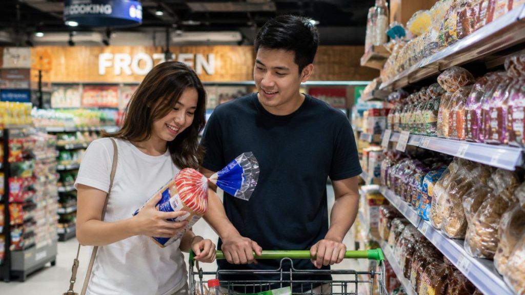 Filipino couple choosing bread together inside a grocery store aisle