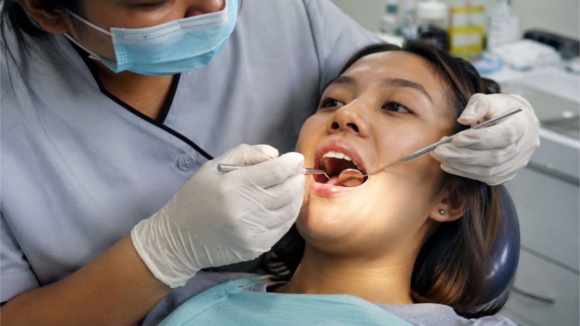 Filipino woman undergoing a dental tongue and oral health examination