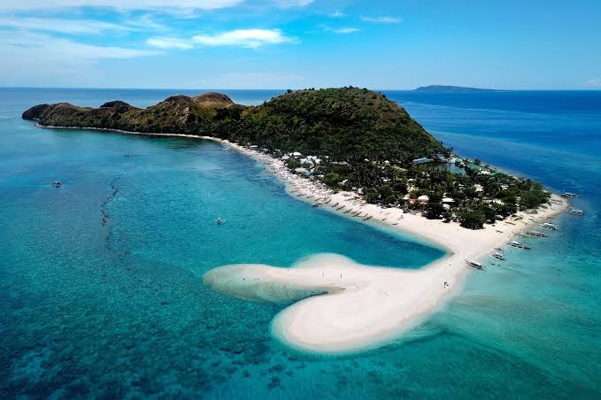 Aerial view of Kawit Sandbar and the rolling green hills of Mararison Island in Antique, Philippines