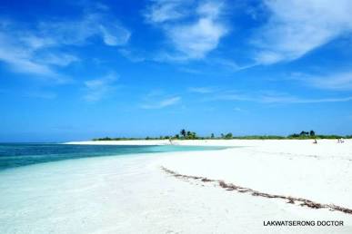 Wide aerial view of Seco Island's remote crescent-shaped white sandbar surrounded by crystal-clear blue Sulu Sea waters in Antique, Philippines